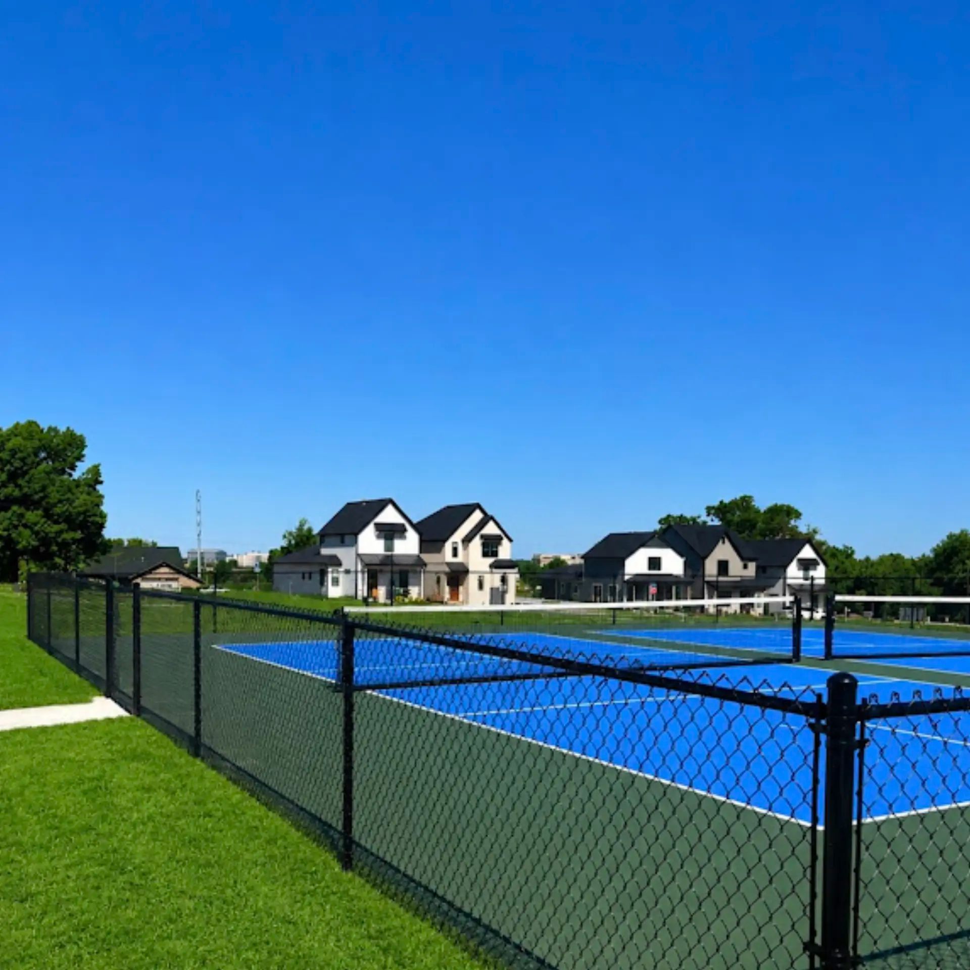 4-foot tall black vinyl-coated chain-link perimeter fence installed around pickleball courts in Rogers, Arkansas.